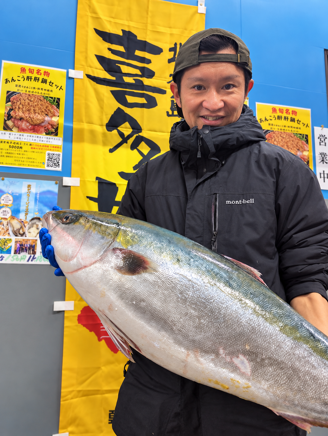 魚を手に取り、状態を確かめる魚屋